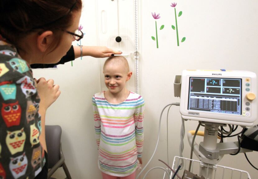 Nichole Cook (left) checks Libby Serber’s height at Children’s Medical Center in Plano.