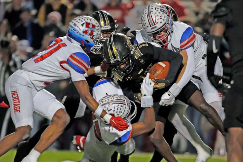 A group of Midlothian Heritage high defenders stop South Oak Cliff WR Daveon Ennis (15)...