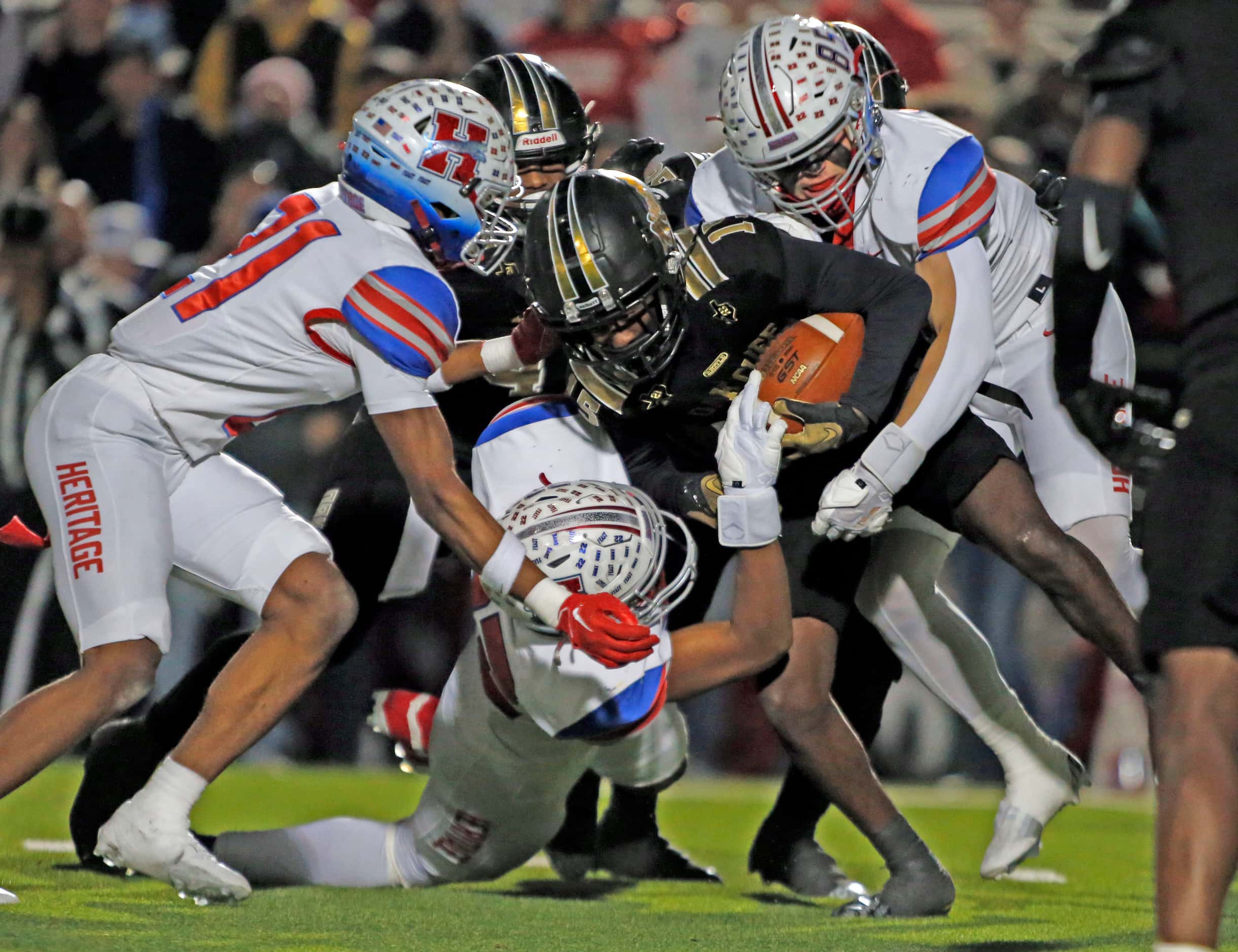A group of Midlothian Heritage high defenders stop South Oak Cliff WR Daveon Ennis (15)...