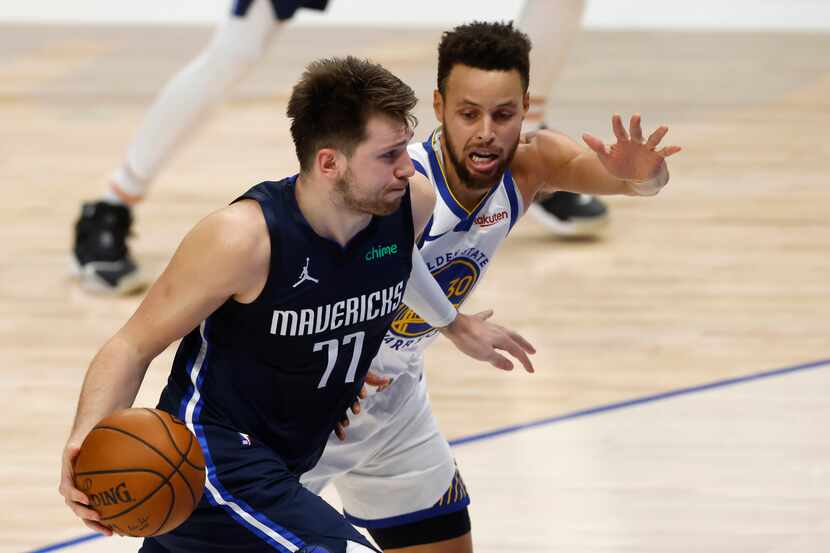 Mavericks guard Luka Doncic (77) drives by Warriors guard Stephen Curry (30) during the...