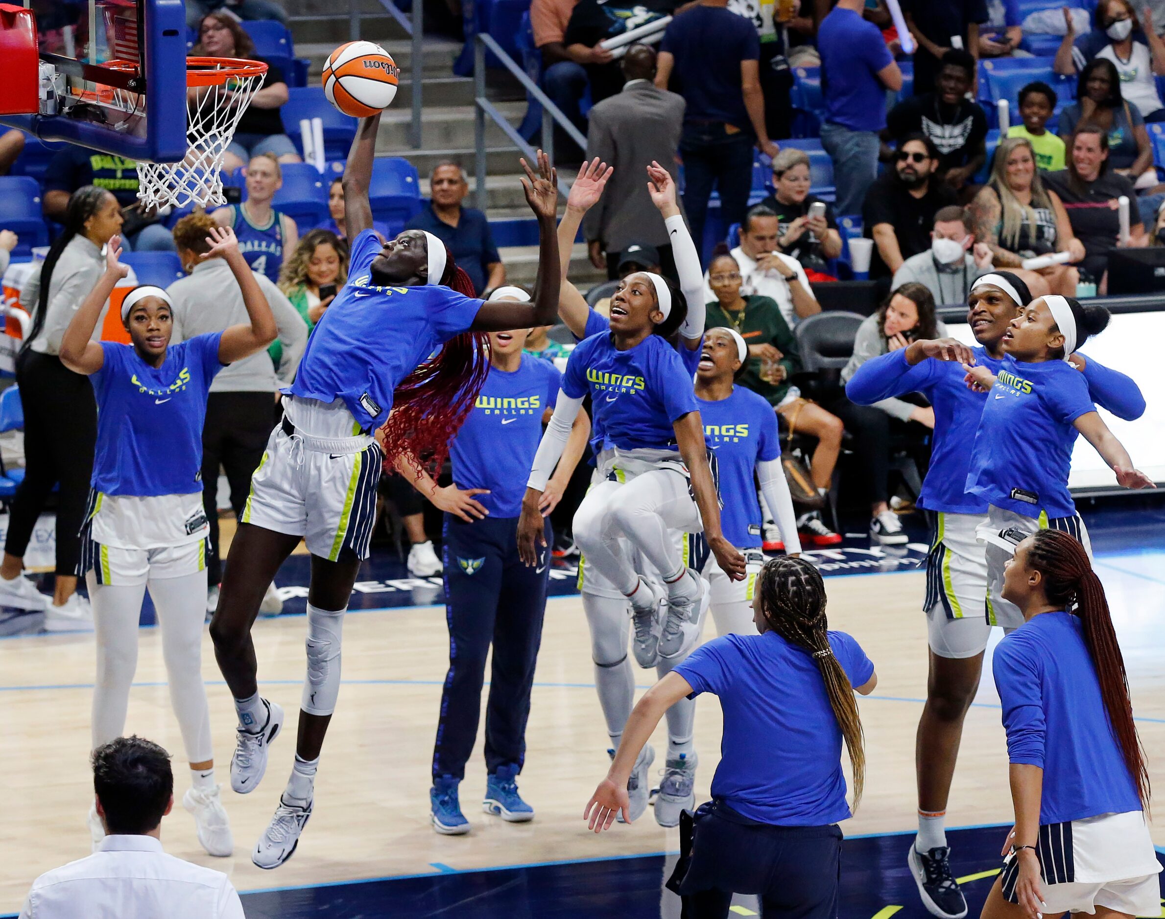 Dallas Wings center Awak Kuier (28) performs her traditional pregame dunk as her teammates...