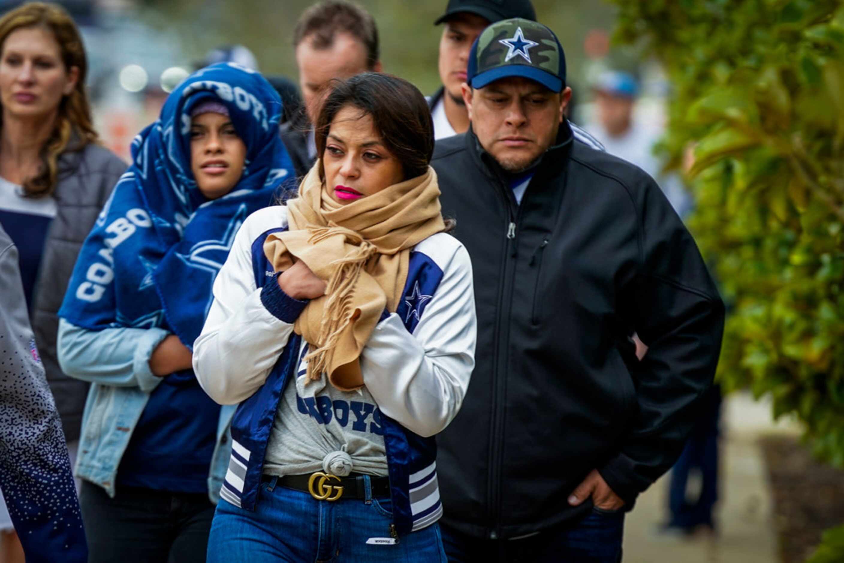 Bundled up fans head to the stadium before an NFL football game between the Dallas Cowboys...
