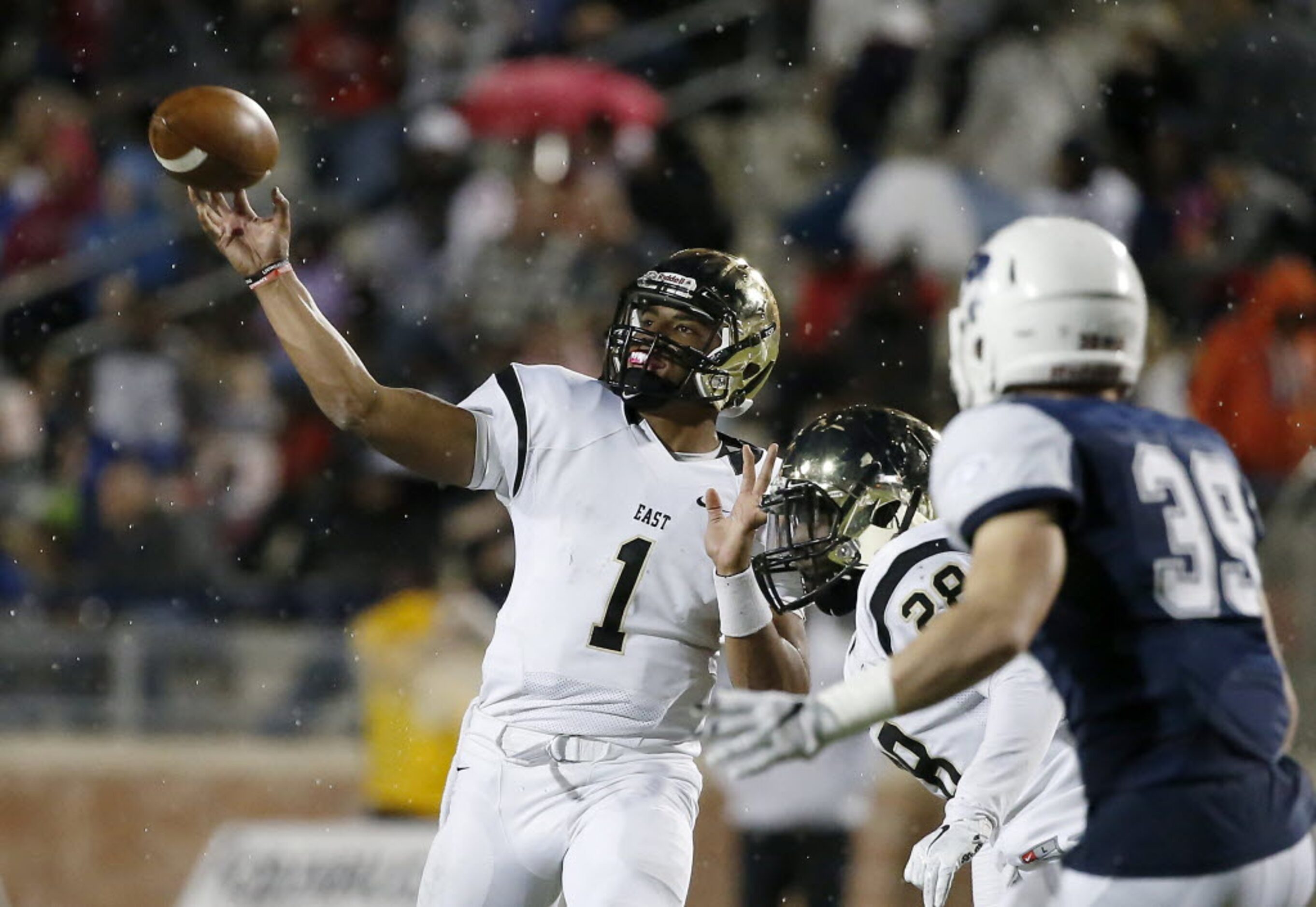 Plano East quarterback Miklo Smalls (1) throws the ball downfield over Desmond Bowden (28)...