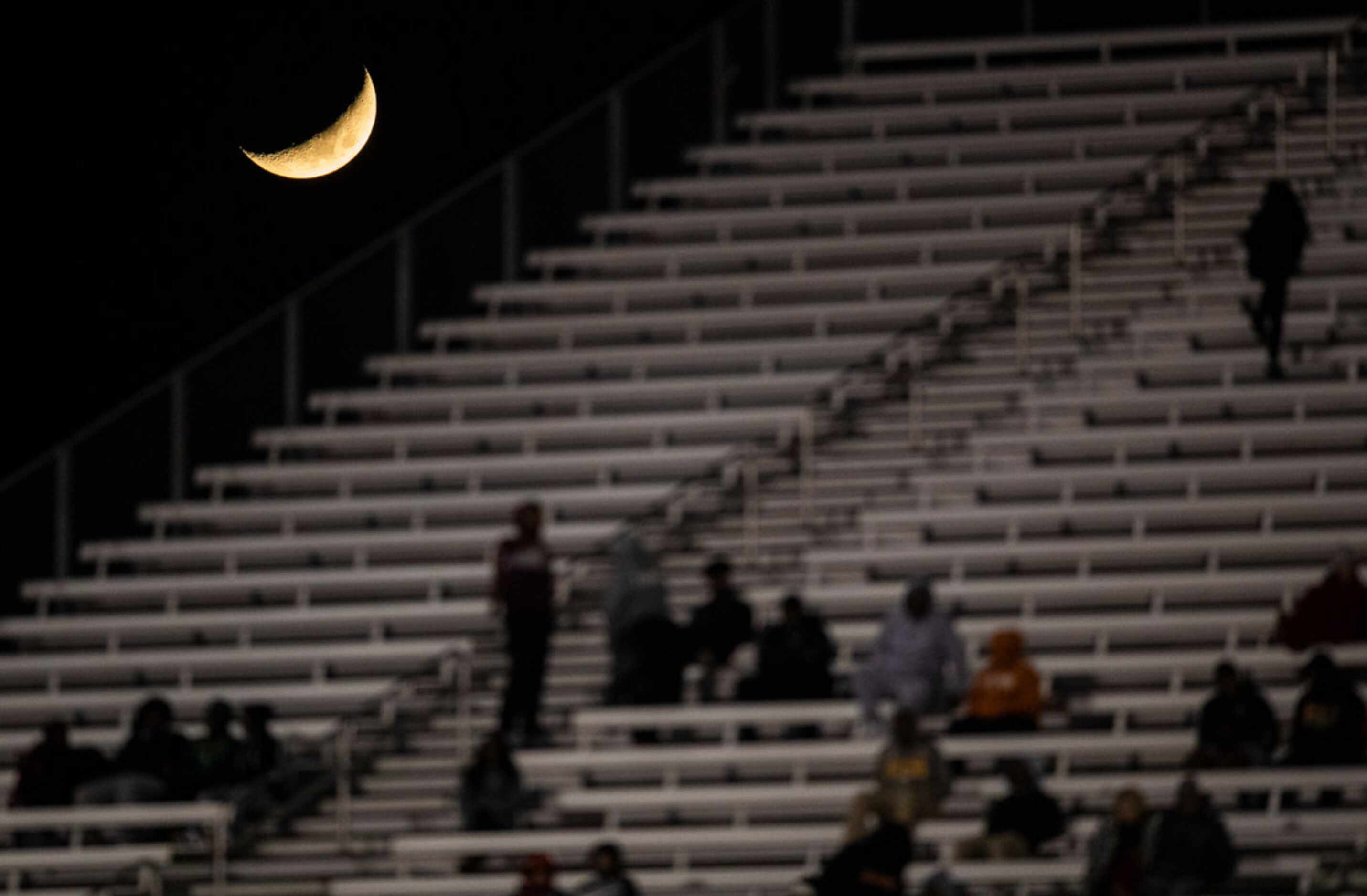 A crescent moon rises over the stands during the fourth quarter of a District 6-5A Division...