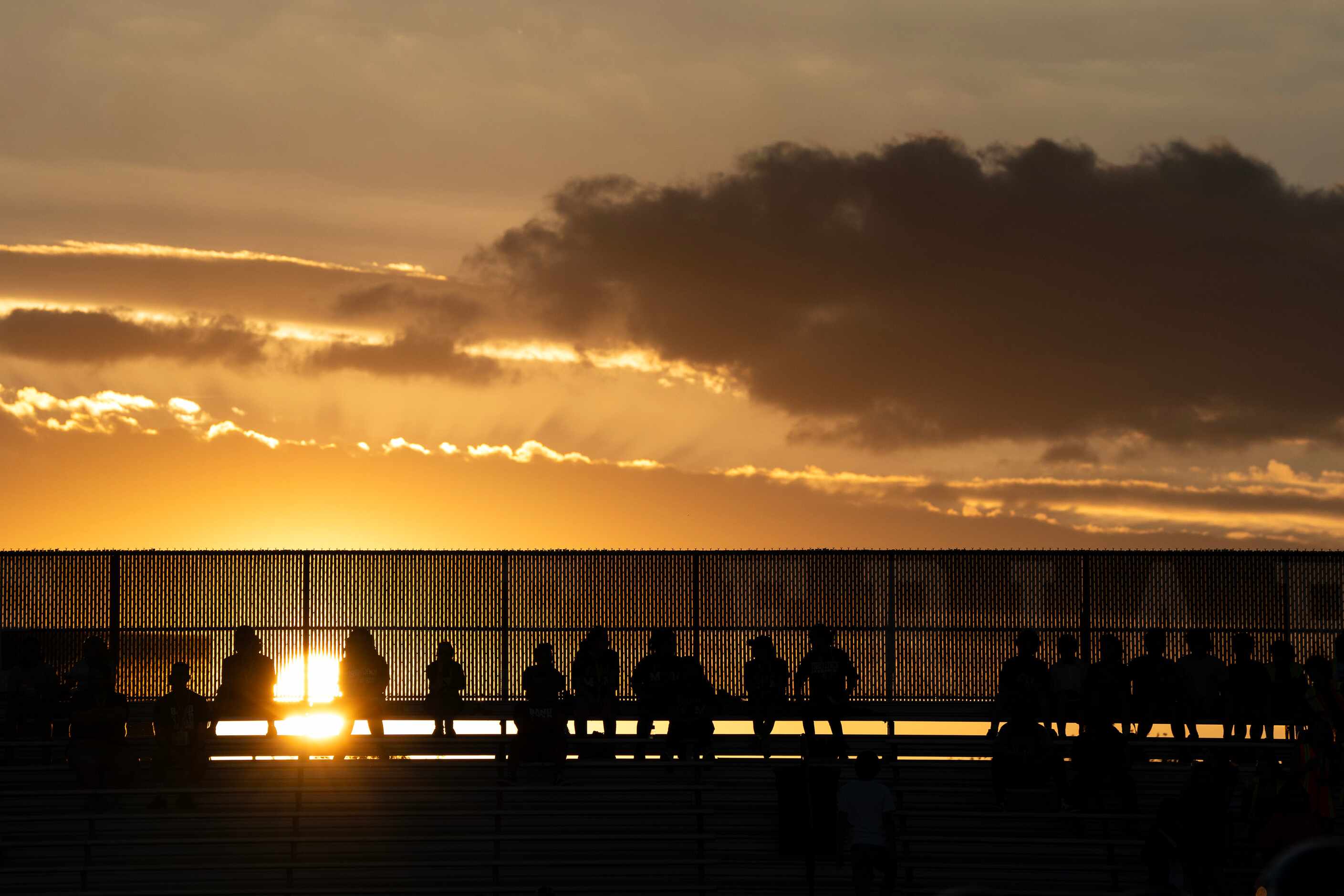 The sun sets behind the bleachers at Roffino Stadium during the first half of a high school...