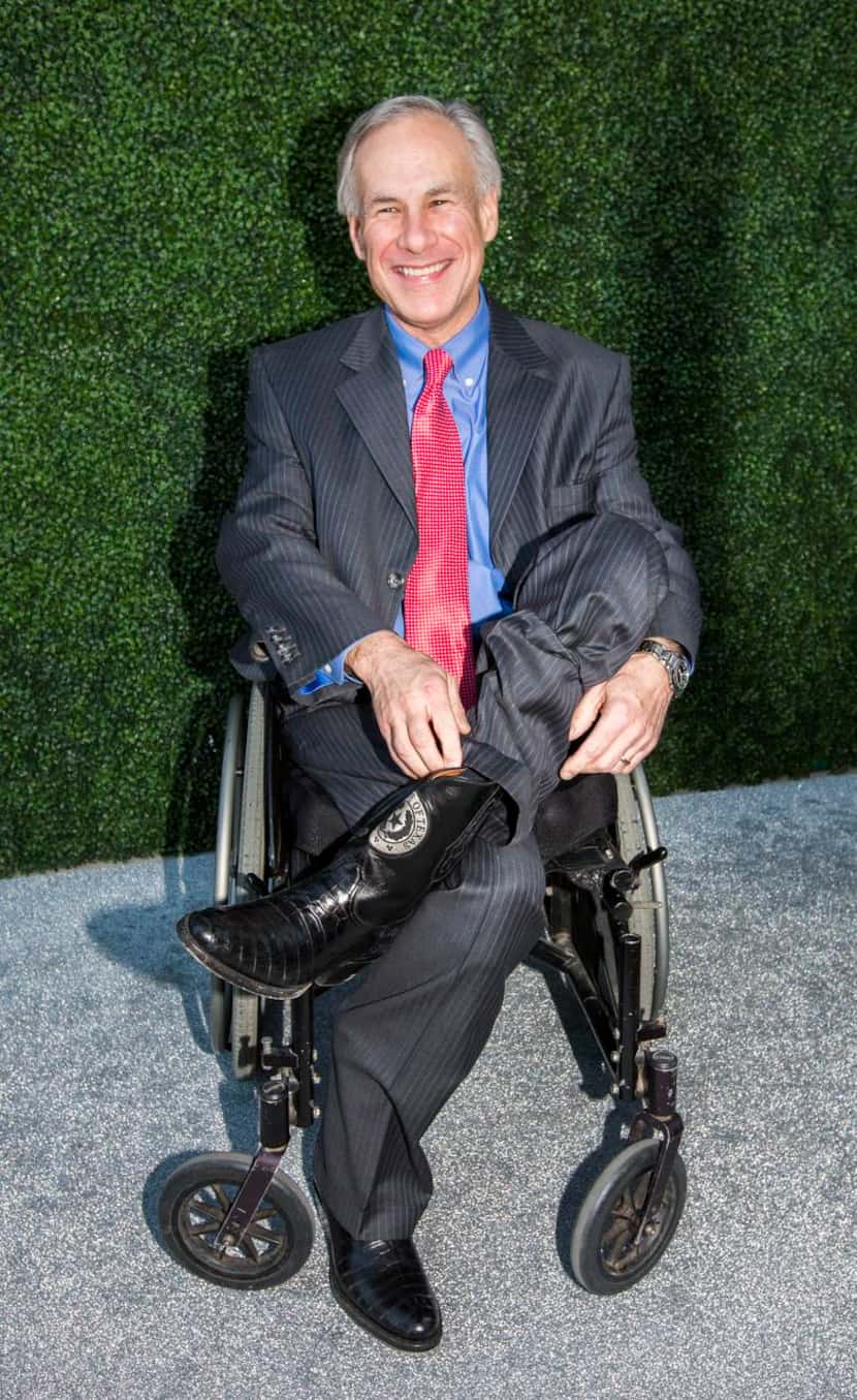 
Texas Governor Greg Abbott shows of his custom boots embellished with the state seal on the...
