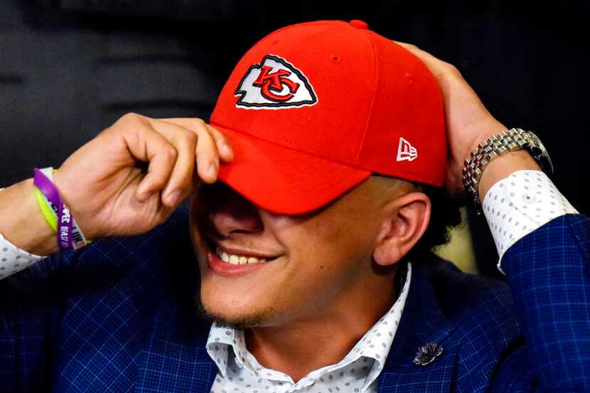 Patrick Mahomes II smiles as he puts on a Kansas City Chiefs hat during an NFL football...
