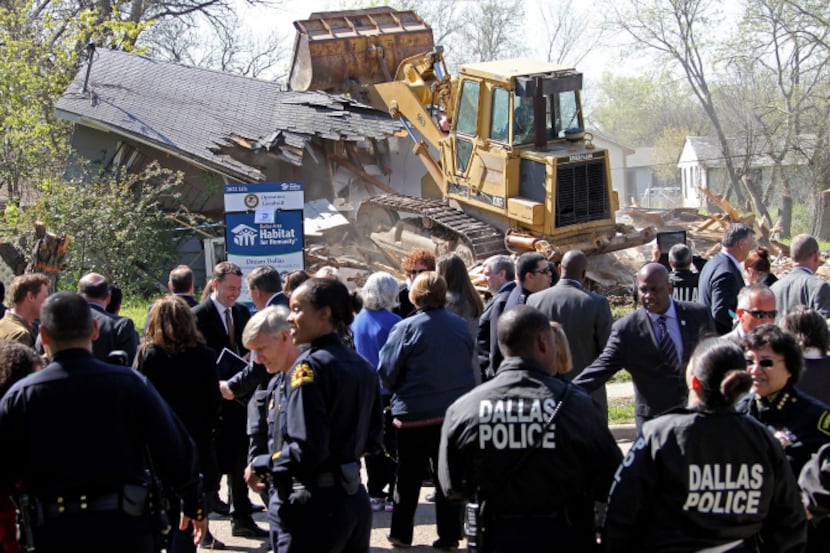 City and federal law enforcement officials were on hand Tuesday as a bulldozer razed a house...