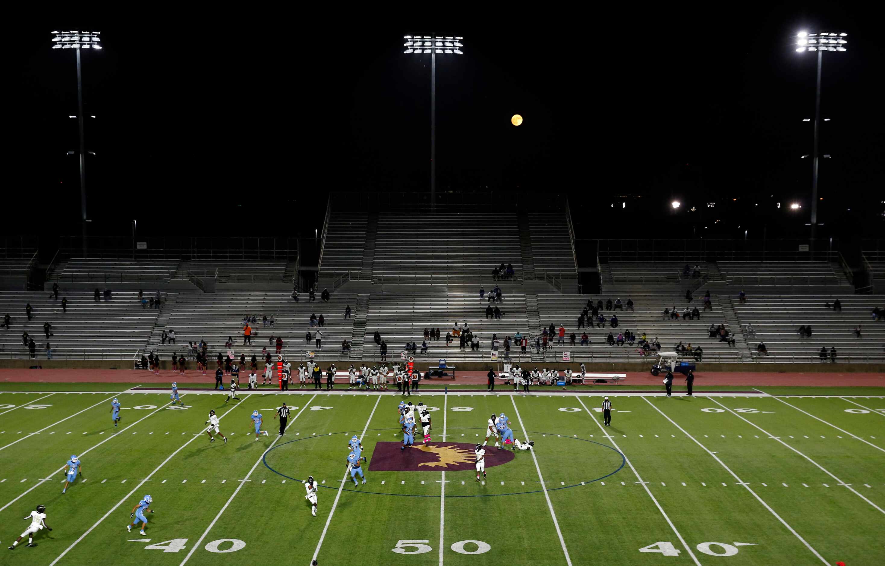 As the Harvest moon rises behind Loos Stadium, Pinkston quarterback Damareya Jones (7)...