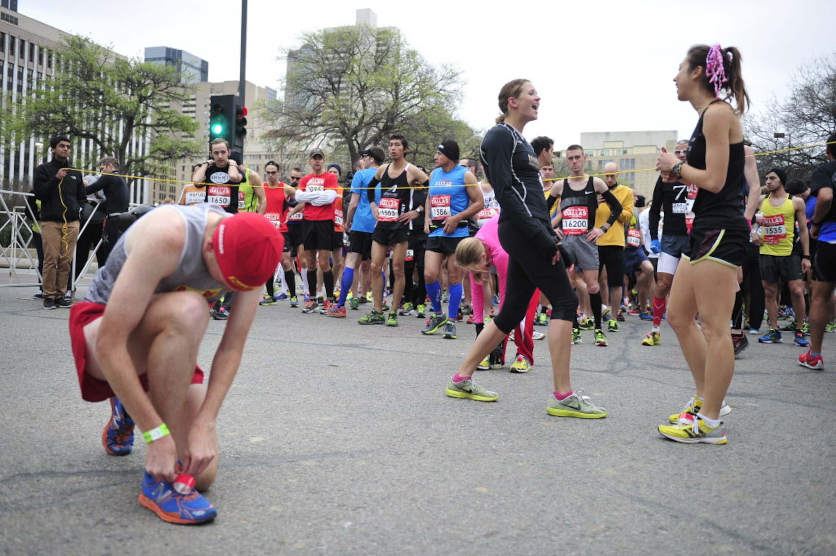 Runners chat near the starting line during the Dallas Rock N' Roll half-marathon on Sunday,...