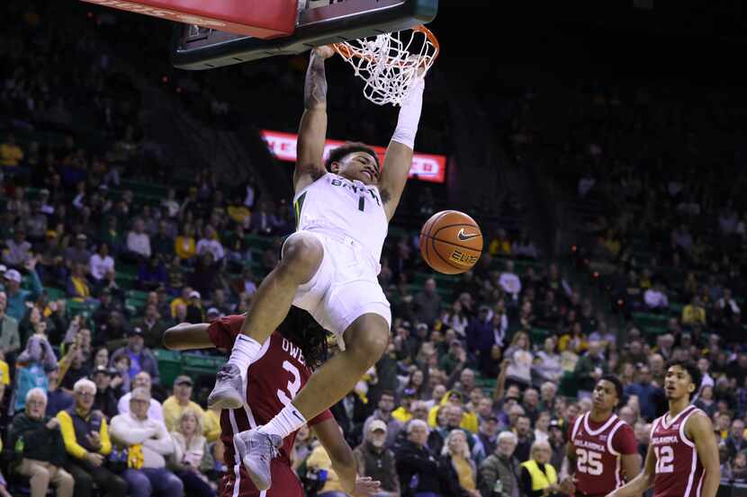 Baylor guard Keyonte George (1) dunks over Oklahoma guard Otega Oweh (3) during the first...