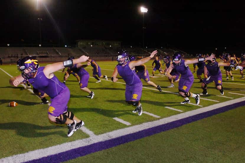 Sanger offensive linemen go through drills during the first practice of the season just...