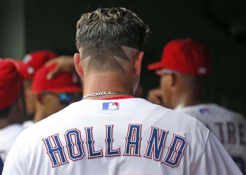 Texas Rangers starting pitcher Derek Holland (45) sports a unique hair cut as he prepares to...