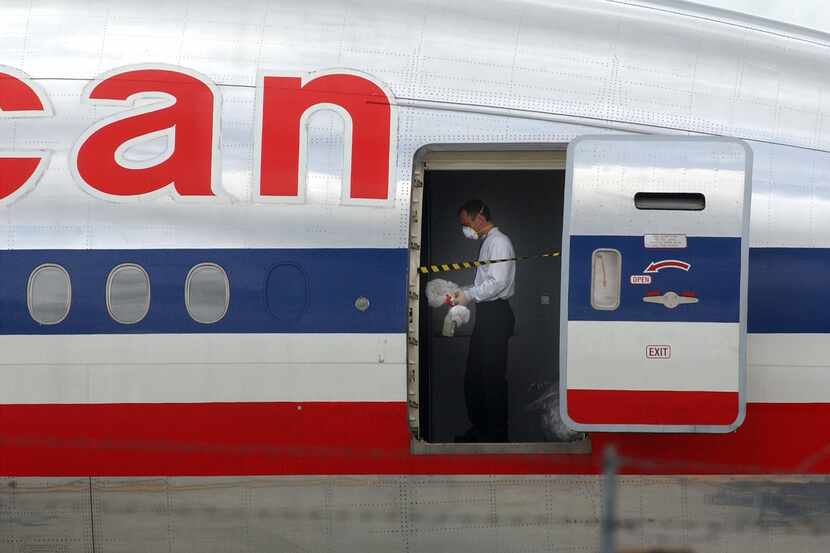 SAN JOSE, CA - APRIL 1:  A worker cleans the plane that carried passengers April 1, 2003 on...
