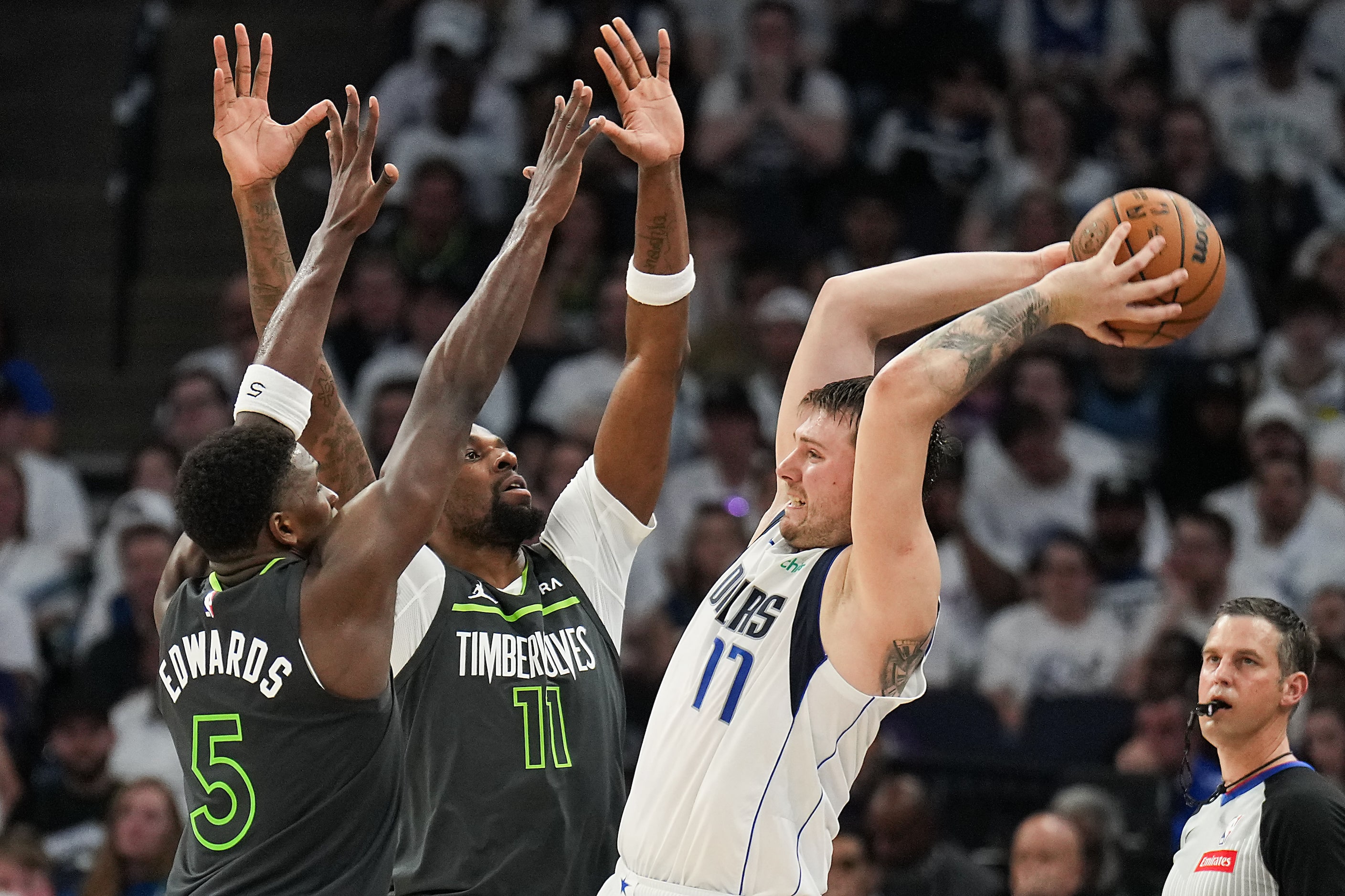 Dallas Mavericks guard Luka Doncic (77) passes out of a double-team from Minnesota...