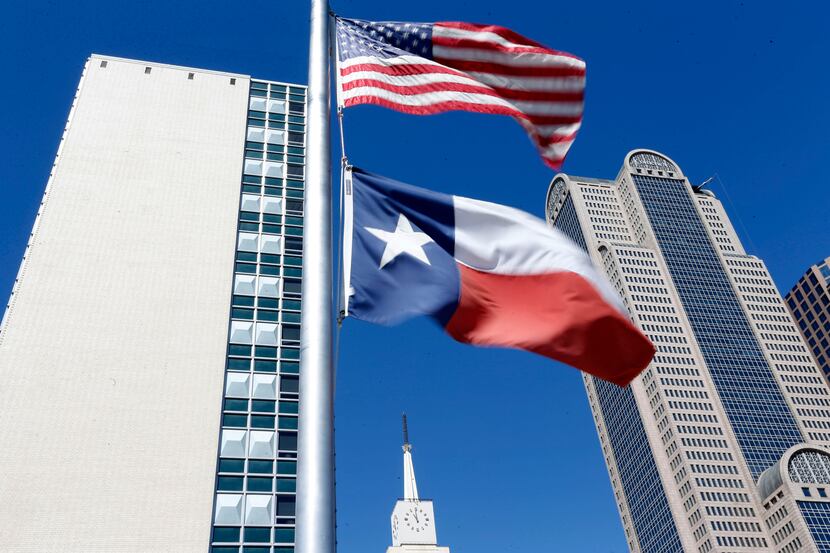 The U.S. and Texas flags fly above The Dallas Morning News building on April 26, 2019, in...