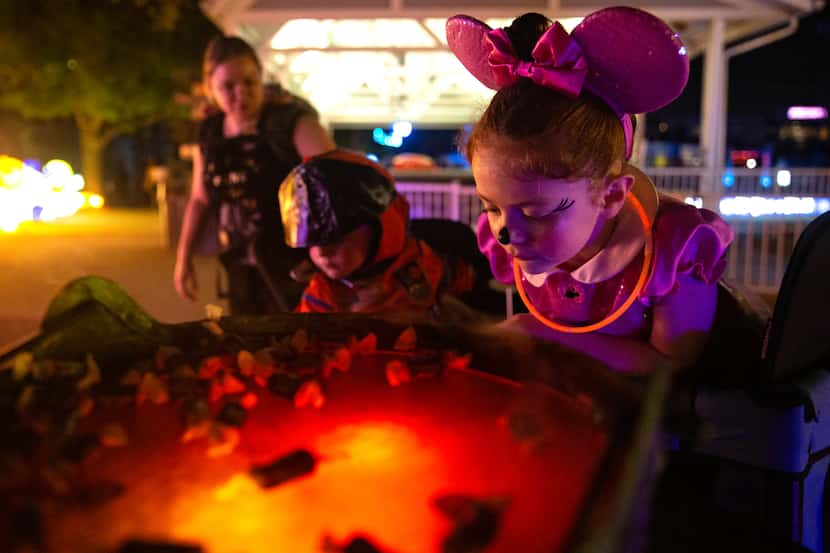 Aurora Deringer, 6, checks out the candy possibilities at a trick-or-treat station at...