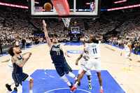 Dallas Mavericks guard Luka Doncic (77) scores past Minnesota Timberwolves center Naz Reid...