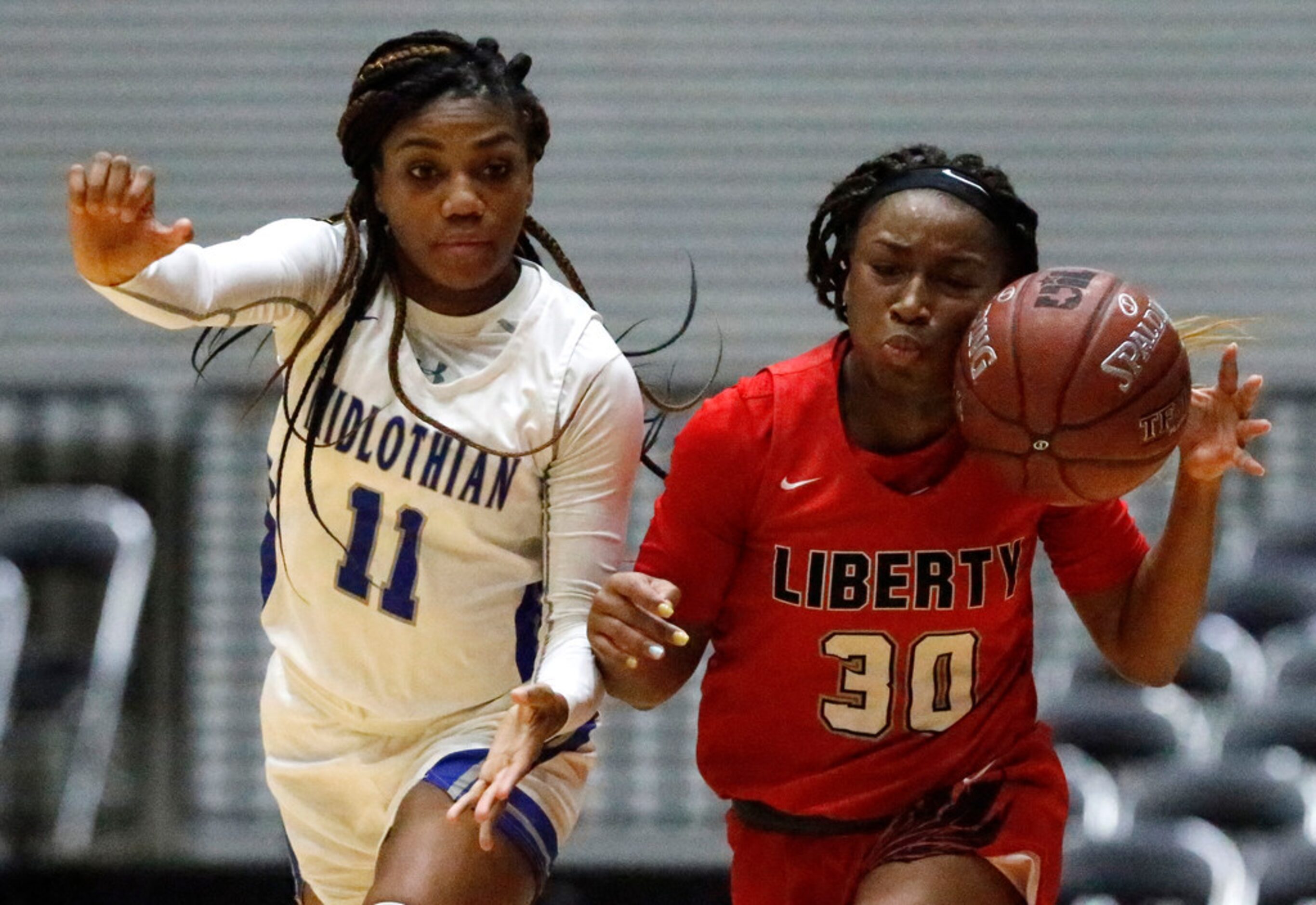 Frisco Liberty High School guard Jazzy Owens-Barnett (30) tries to dribble past Midlothian...