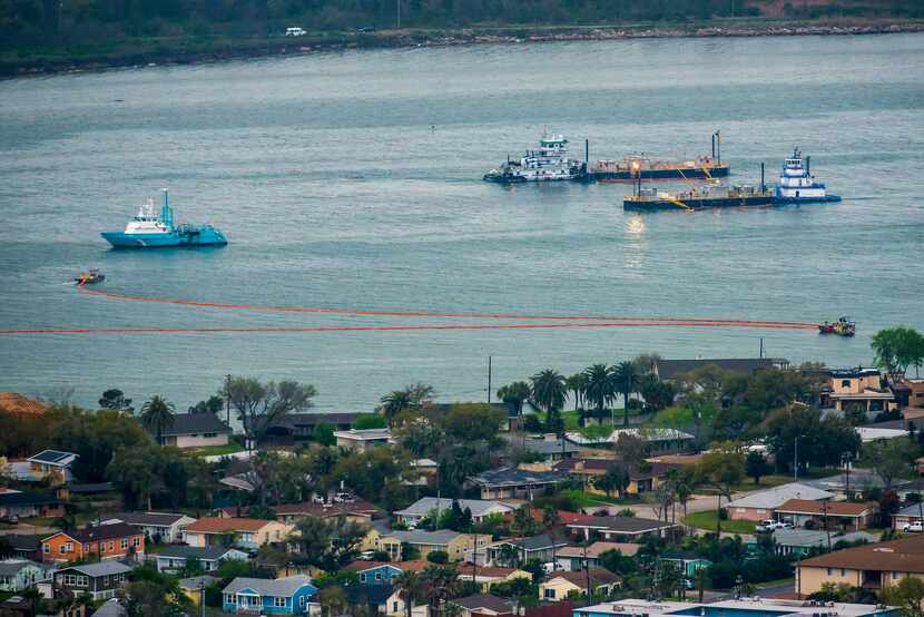 Oil containment booms were spread out in Galveston Harbor on Sunday.