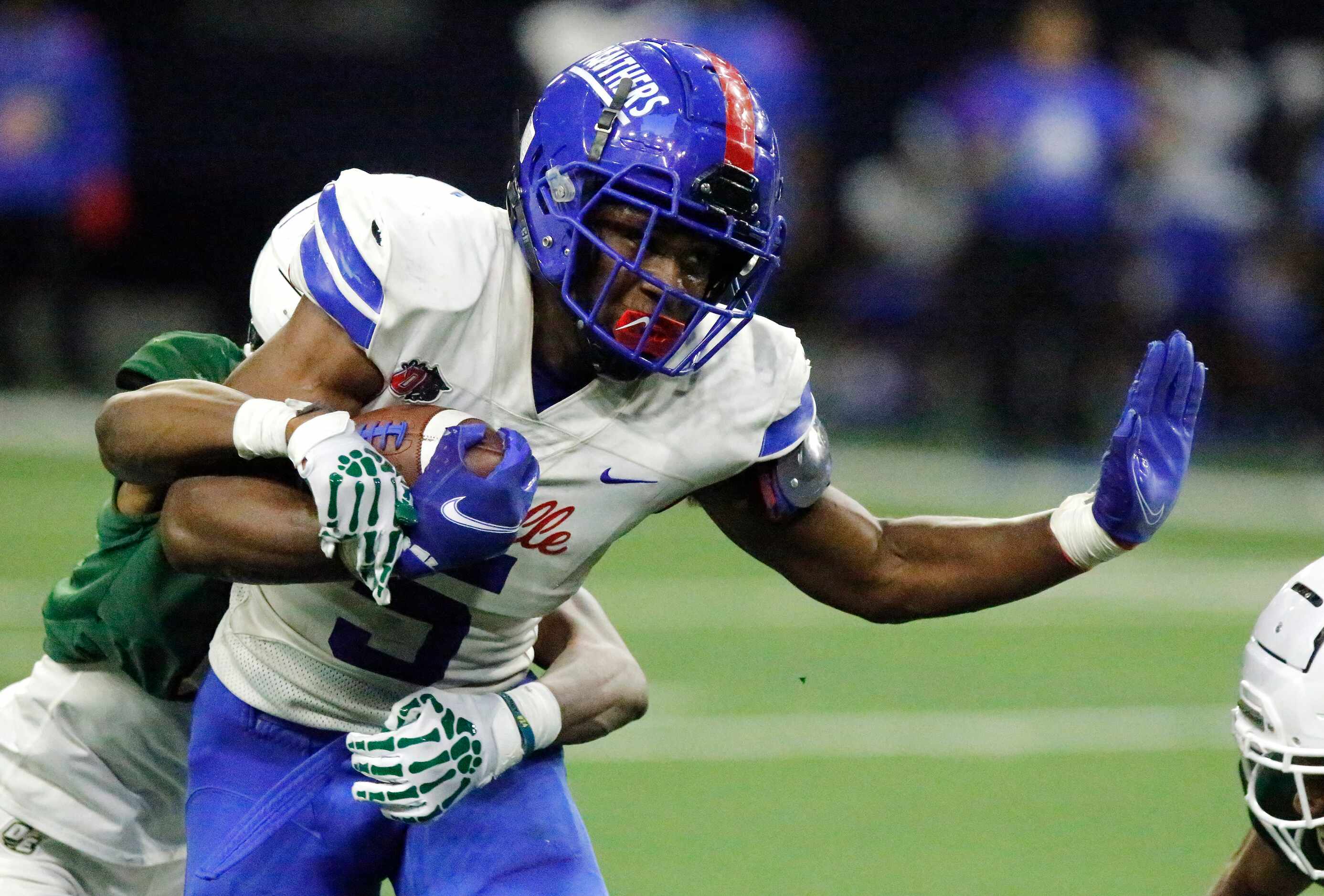Duncanville High School running back Malachi Medlock (5) is tackled by DeSoto High School...