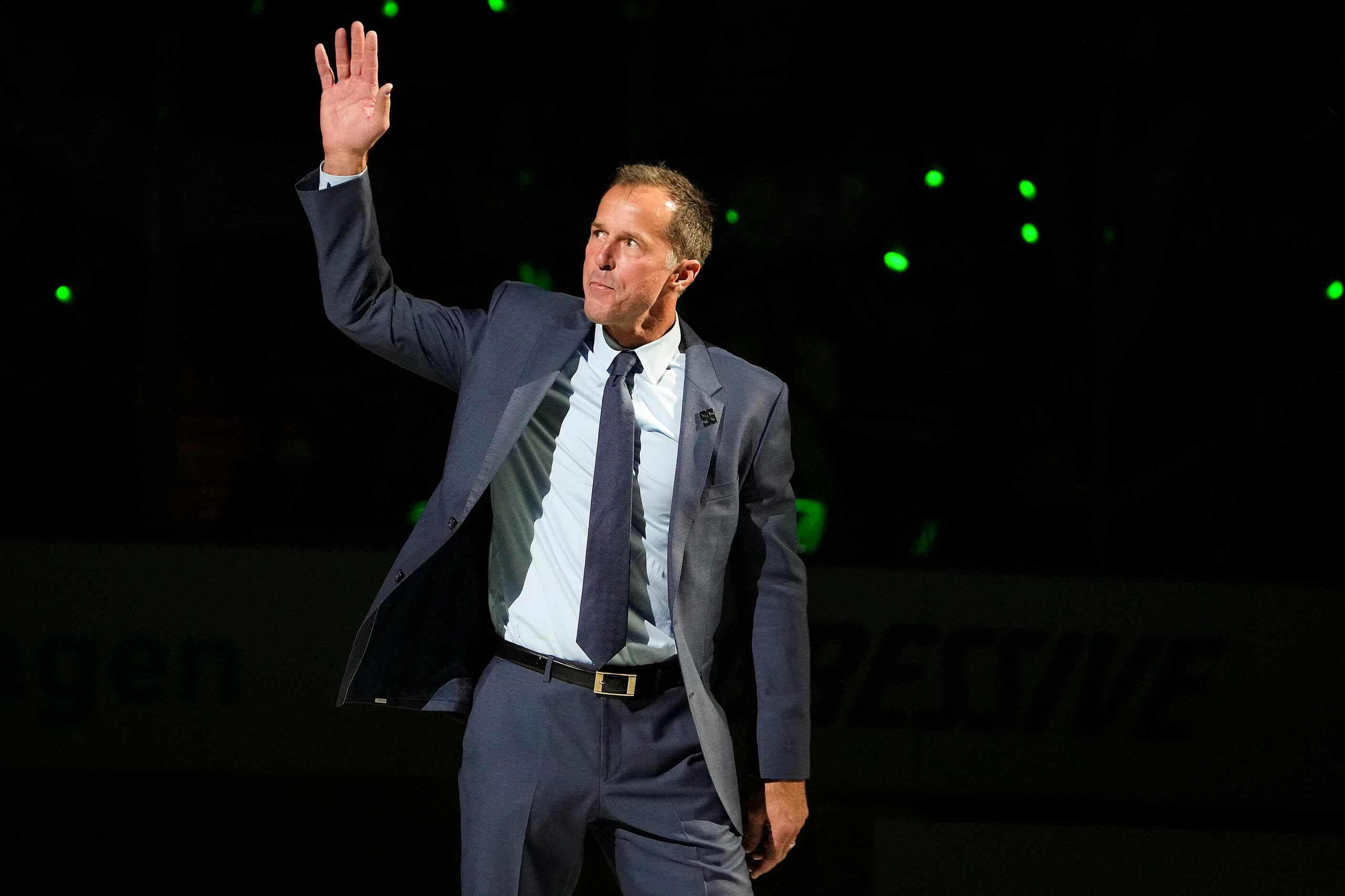 Former Dallas Stars player Mike Modano waves to the crowd as he introduced during ceremonies...