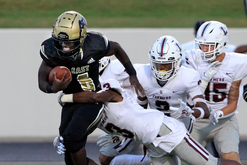 Plano East’s Ismail Mahdi (6) picks up a couple of yards, but is hit by many Lewisville...