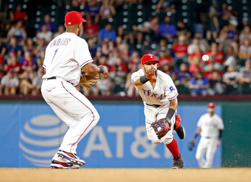 Texas Rangers second baseman Rougned Odor (12) tosses the ball to shortstop Elvis Andrus (1)...