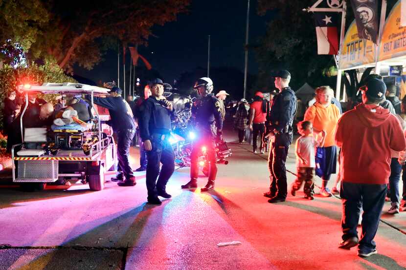 Dallas Fire-Rescue EMS loads a wounded person onto a cart after a shooting at the State Fair...