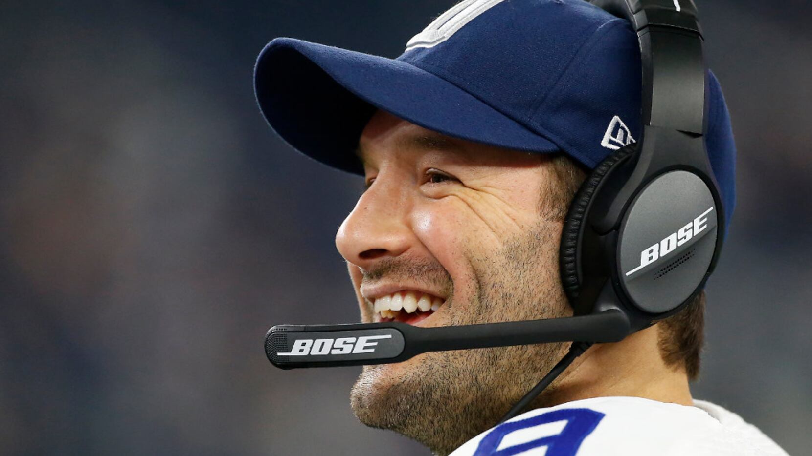 Dallas Cowboys quarterback Tony Romo (9) smiles on the sideline during the fourth quarter...