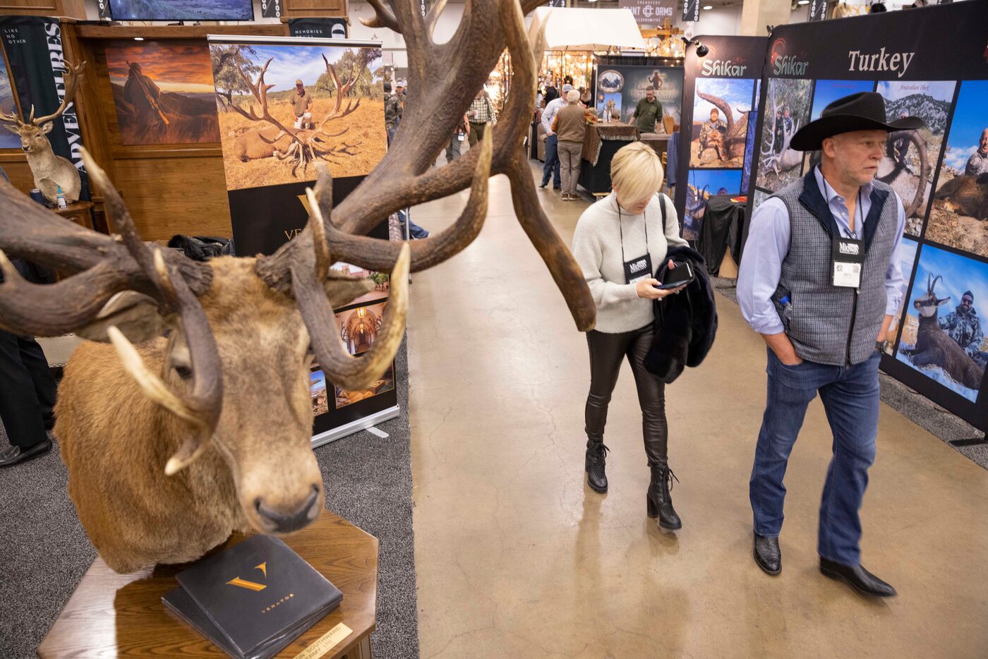 People walk by the booths at the Dallas Safari Club Convention and Sporting Expo at Kay...