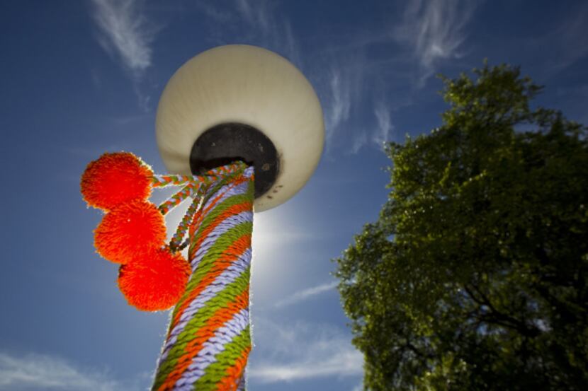 Three light poles and a street sign outside the Lakewood Branch Library in Dallas have been...