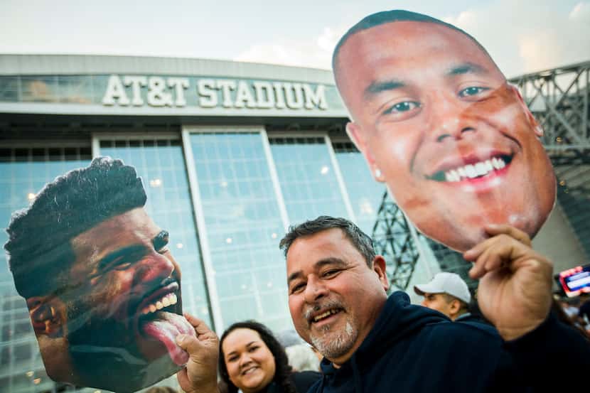 Dallas Cowboys fan Jerry Reyes holds up pictures of running back Ezekiel Elliott (left) and...