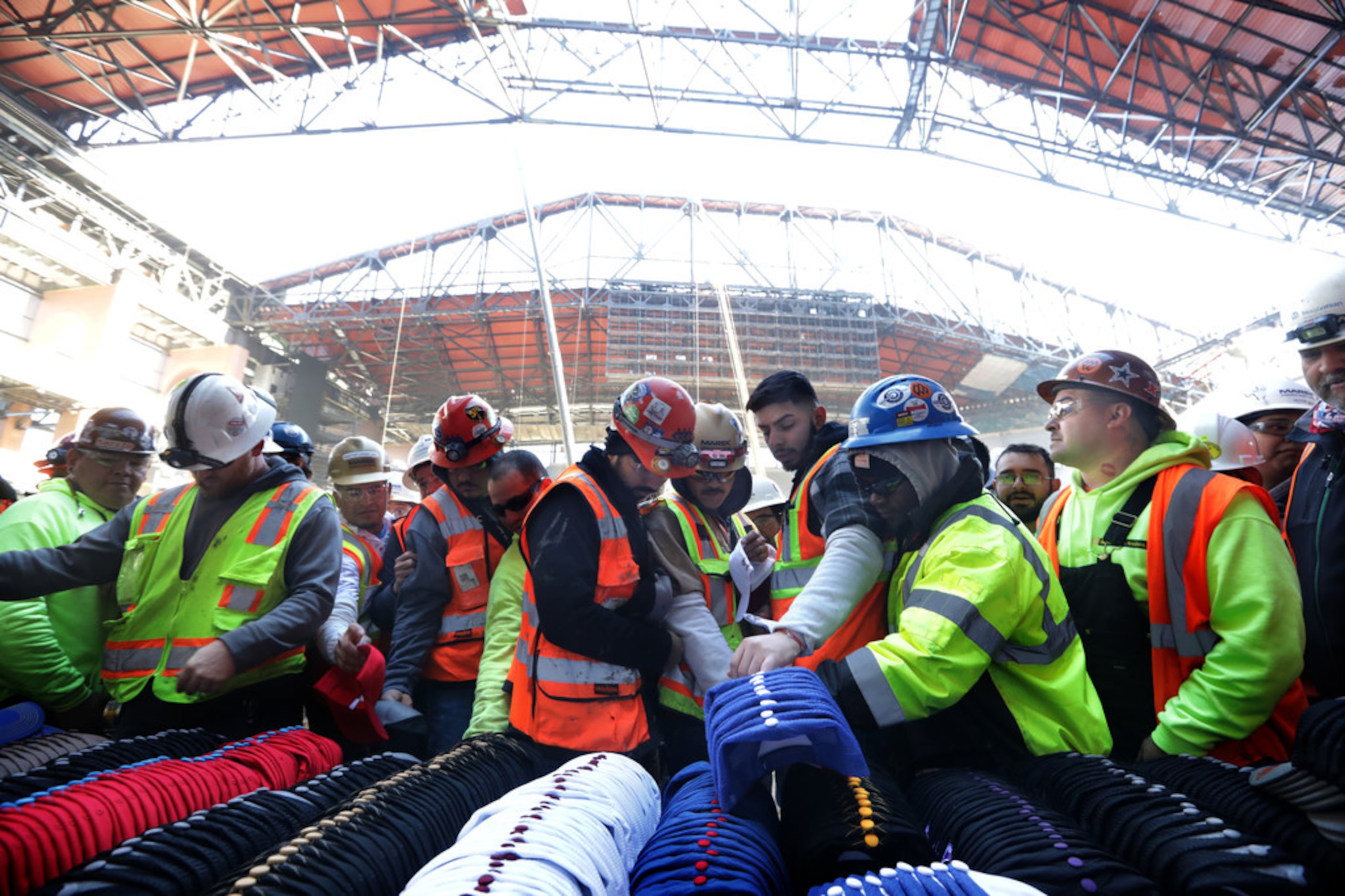 Workers receive free food, baseball caps, and commemorative Holiday ornaments during a...