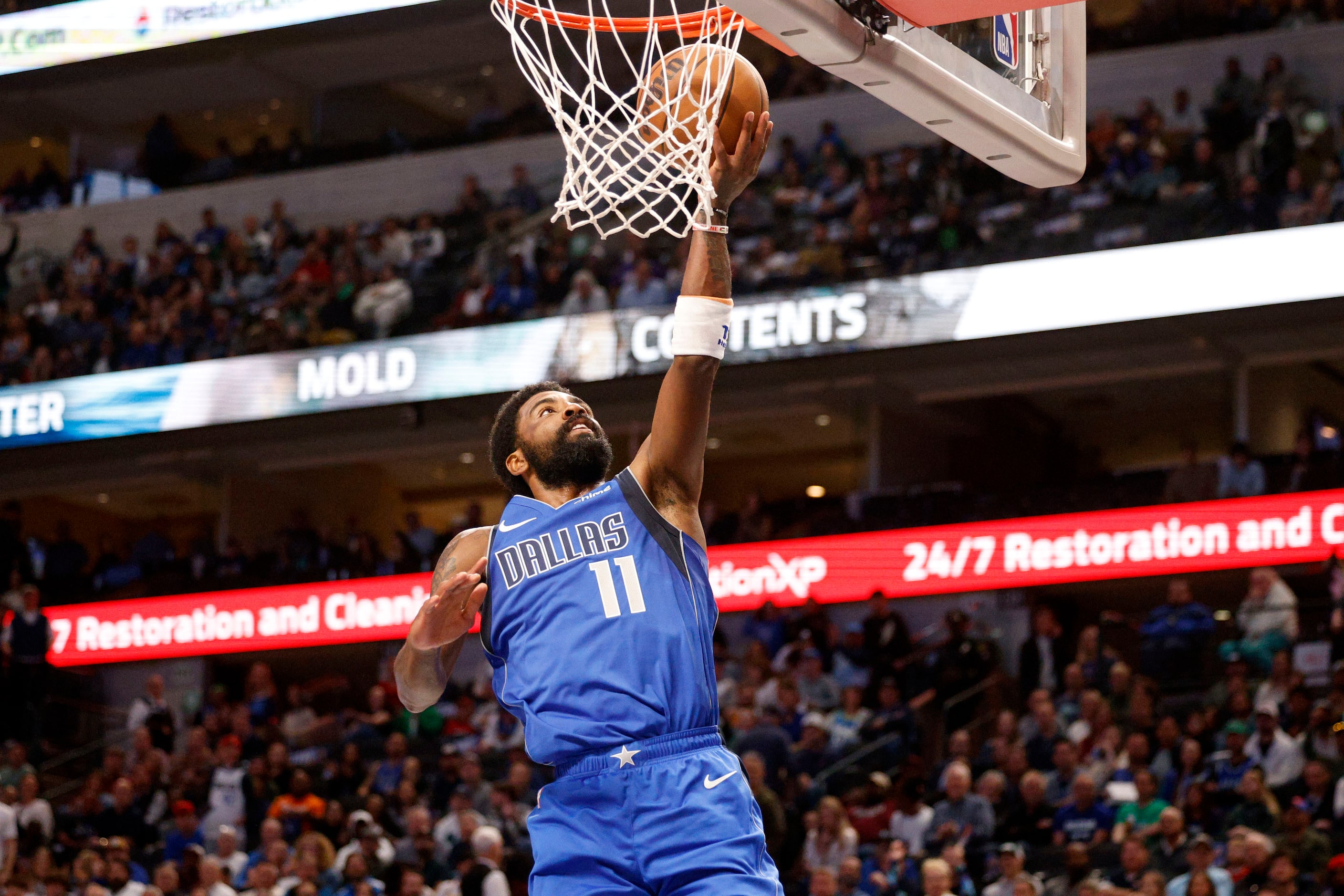 Dallas Mavericks guard Kyrie Irving (11) lays up a ball during the first half of an NBA...