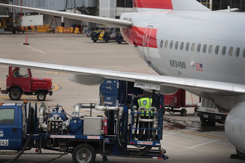 CHICAGO, IL - MAY 11:  A worker loads fuel onto an American Airlines aricraft at O'Hare...