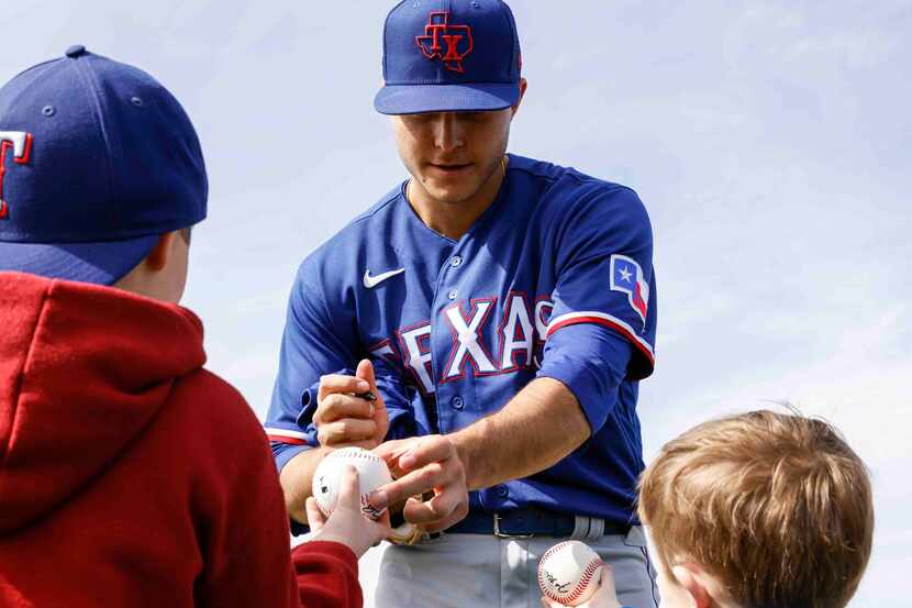Texas Rangers pitching prospect Jack Leiter gives an autograph to Guy Jones, 7, left, and...