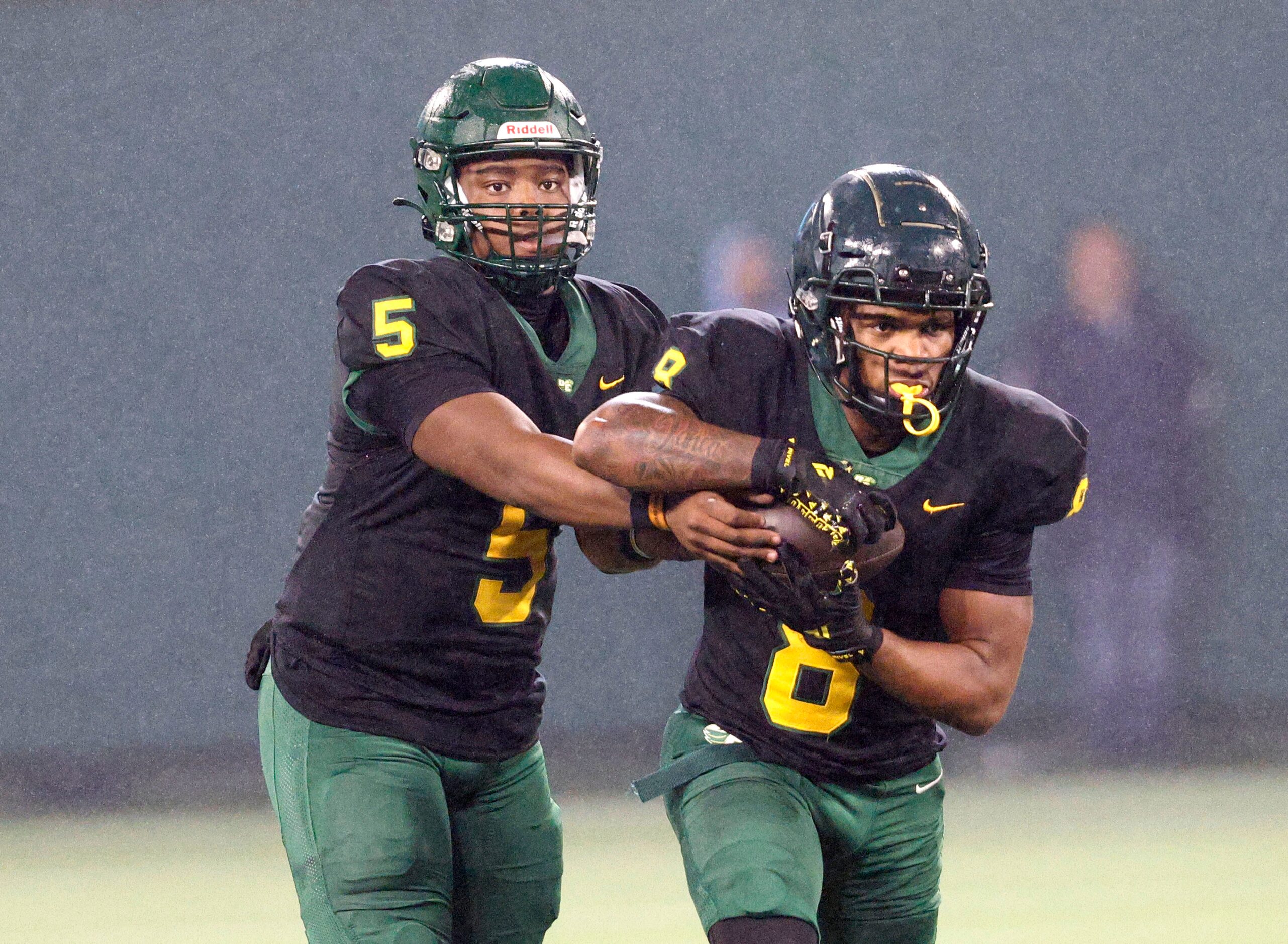 DeSoto's Darius Bailey (5) hands off to DeSoto's Jaden Trawick (8) during the second half of...