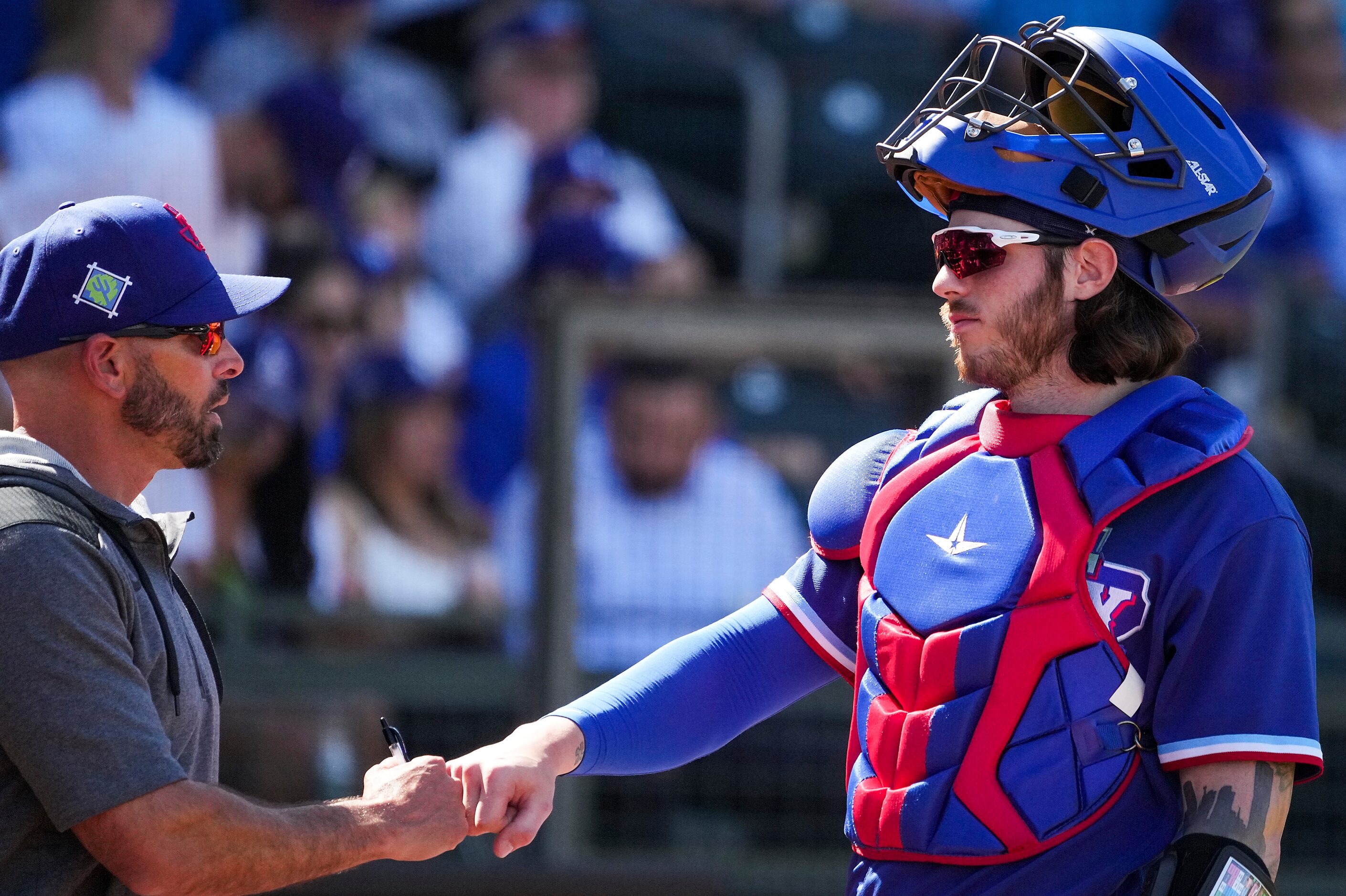 Texas Rangers catcher Jonah Heim first bumps with manager Chris Woodward during the sixth...