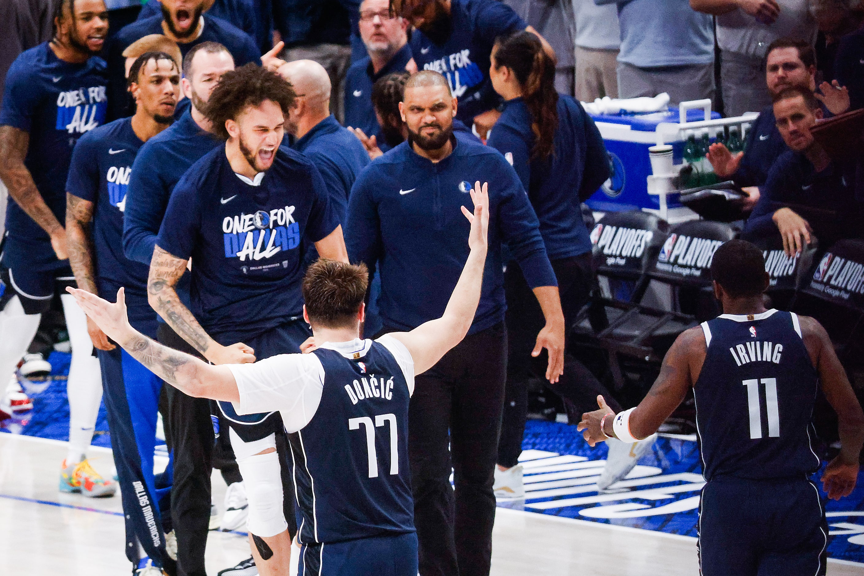 Dallas Mavericks guard Luka Doncic and Kyrie Irving celebrate with the bench players after...