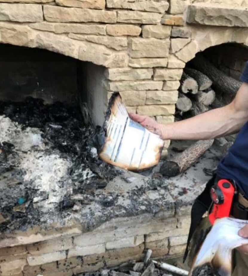A firefighter displayed a partially burned medical record found in an outdoor fireplace at...