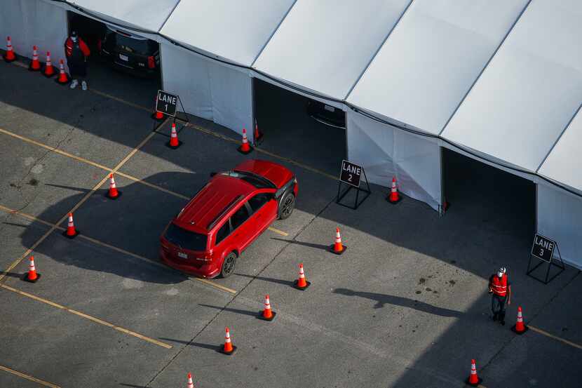 A car enters the testing tent at Ellis Davis Fieldhouse in Dallas on Friday.