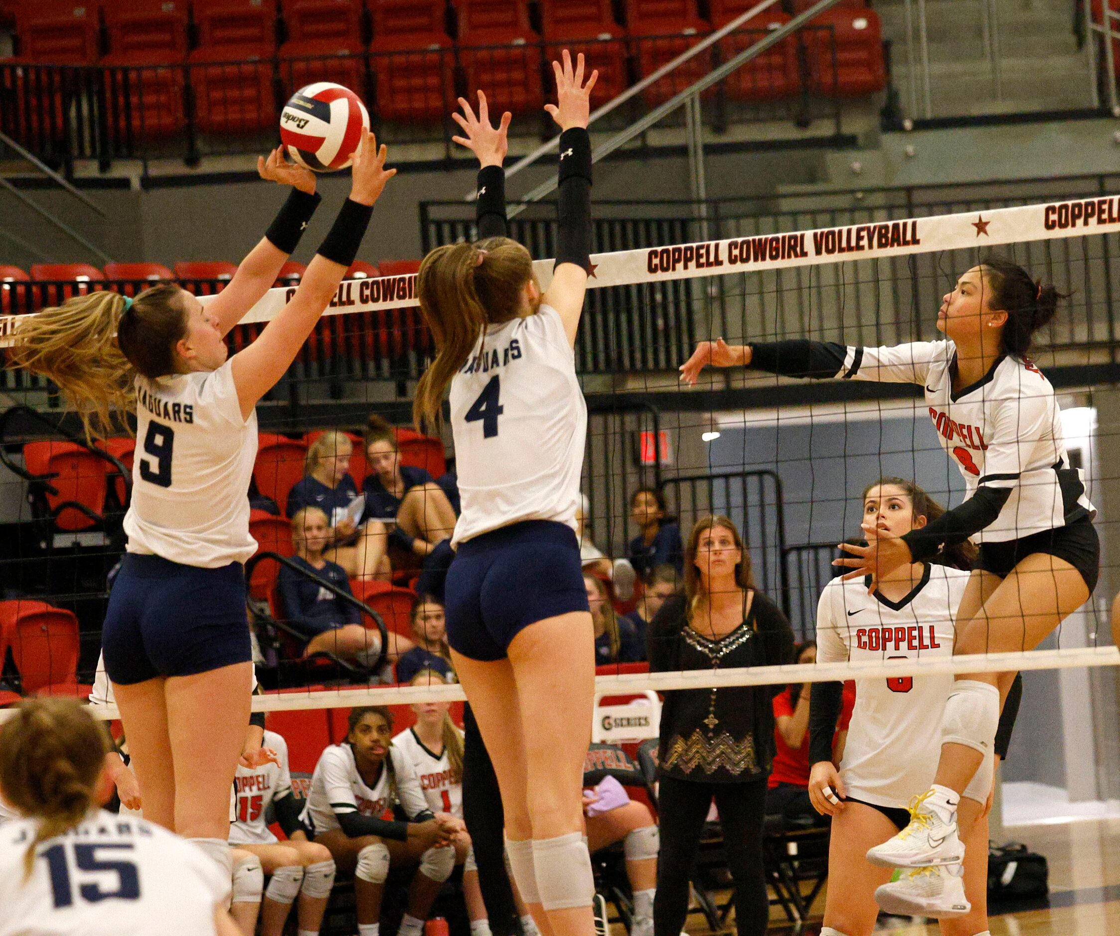 Coppell's Coppell's Alena Truong (9) spikes the ball as  Flower Mound's Cat Young (9) and...