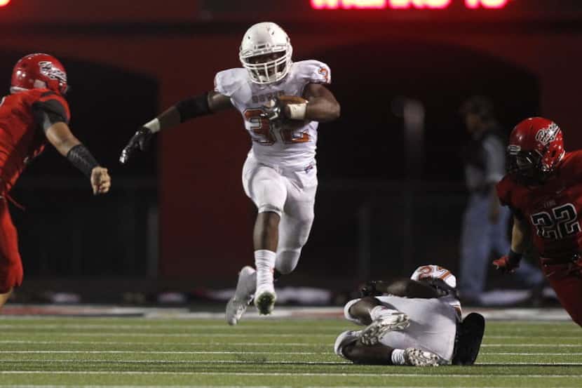 Arlington Bowie running back DeAndre Cook (32) leaps a downed player as Cedar Hill...