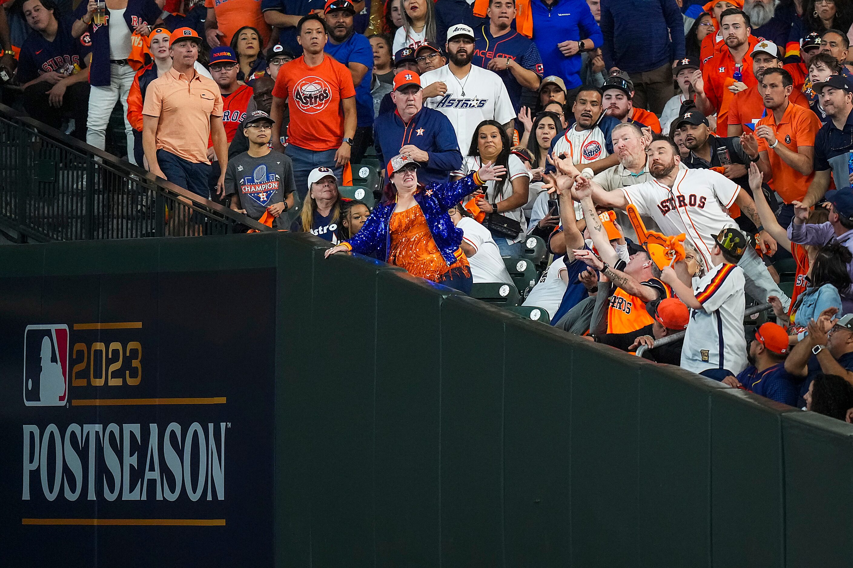 Fans reach for a foul ball off the bat of during the Houston Astros shortstop Jeremy Pena...