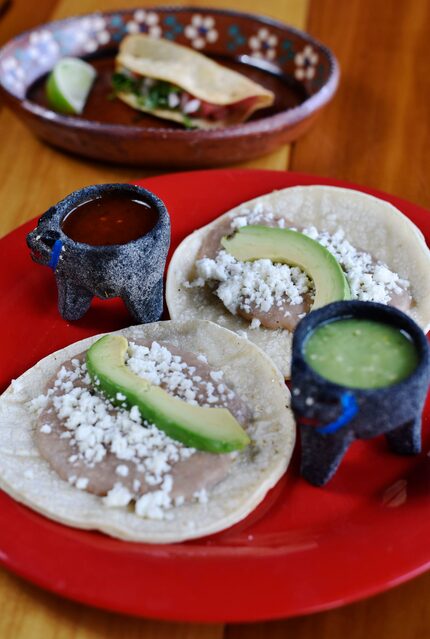 Tacos de frijoles con queso, servidos con salsa roja de El Come Taco.