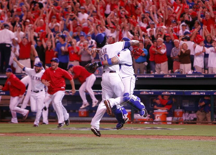 Rangers Neftali Feliz (30) and Bengie Molina (11) celebrate after the final out against the...