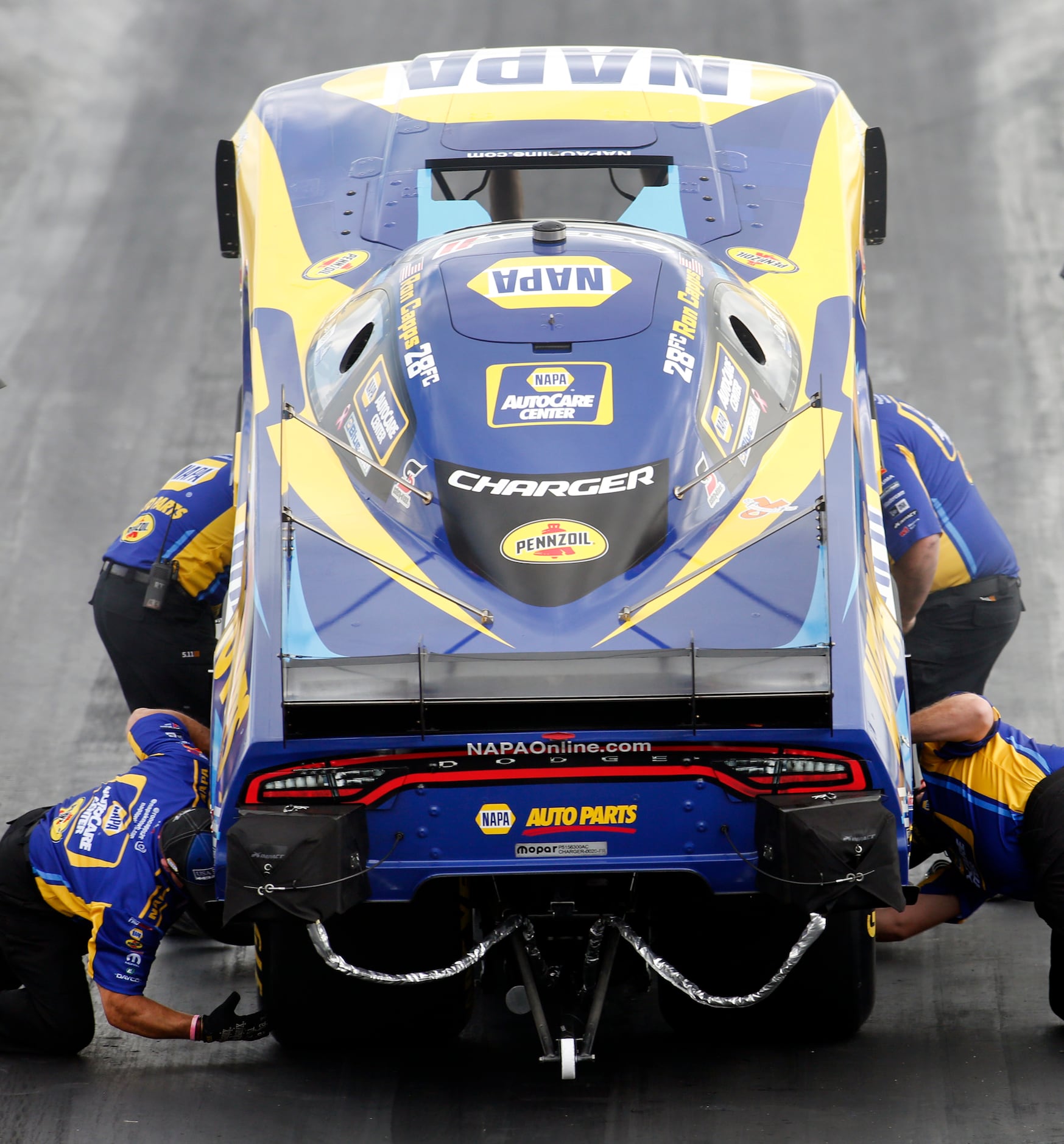 Members of the NAPA racing crew make last second preparations to the race car for driver Ron...