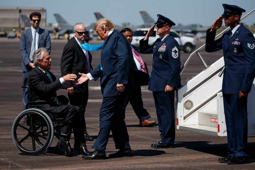 Texas Gov. Greg Abbott greets President Donald Trump as he arrives at Ellington Joint...