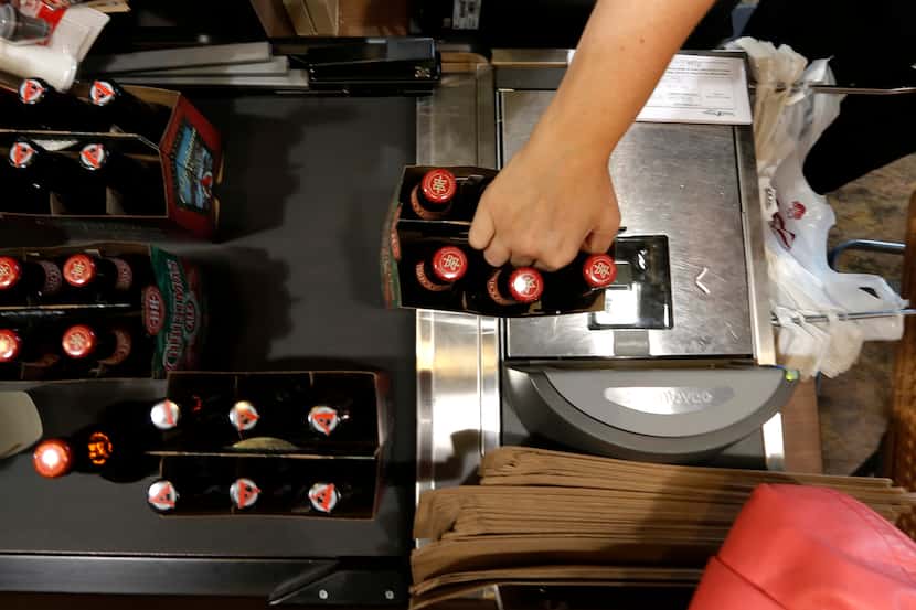 Alicia Richmond rings up some beer at the new Total Wine & More store in Plano November 8,...